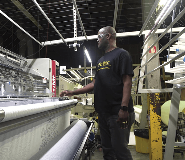 One of BIA’s longest-serving employees, Rosemond St. Cyr, operates a quilting machine in its manufacturing facility in New Jersey.